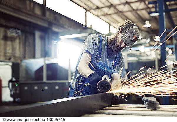 Manual worker using welding machine in workshop