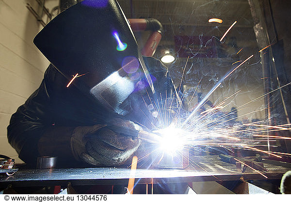 Manual worker using welding torch at workshop