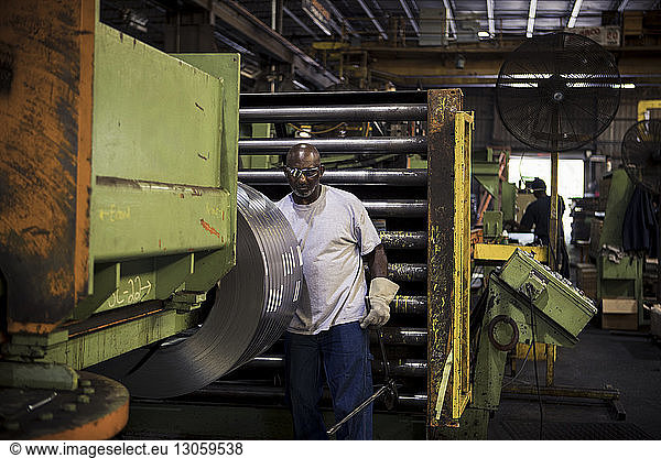 Manual worker working at machinery in metal industry