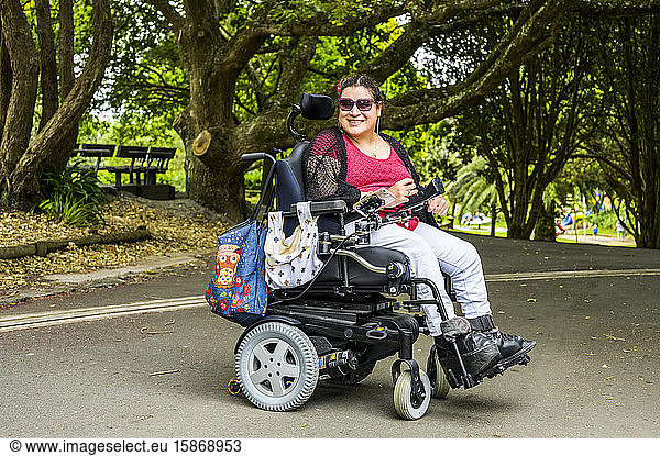 Maori-Frau mit Cerebralparese in einem Rollstuhl in einer Parkanlage; Wellington  Neuseeland