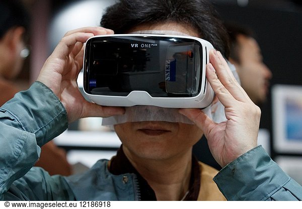 March 3  2018  Yokohama  Japan - A man tries out a ZEISS VR One Plus (Virtual Reality Headset) at the CP+ Camera & Photo Imaging Show 2018 in Pacifico Yokohama. Japan's largest camera and photo imaging exhibition bring together 1 123 exhibitor booths during the four-day trade show at the Pacifico Yokohama and OSANBASHI Hall. Organizers expect approximately 70 000 visitors until March 4th.