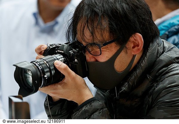 March 3  2018  Yokohama  Japan - A man tries out an Olympus camera at the CP+ Camera & Photo Imaging Show 2018 in Pacifico Yokohama. Japan's largest camera and photo imaging exhibition bring together 1 123 exhibitor booths during the four-day trade show at the Pacifico Yokohama and OSANBASHI Hall. Organizers expect approximately 70 000 visitors until March 4th.