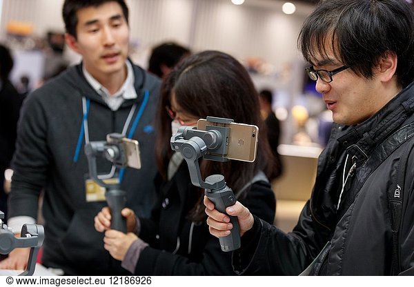 March 3  2018  Yokohama  Japan - Visitors try out the new DJI OSMO MOBILE 2 at the CP+ Camera & Photo Imaging Show 2018 in Pacifico Yokohama. Japan's largest camera and photo imaging exhibition bring together 1 123 exhibitor booths during the four-day trade show at the Pacifico Yokohama and OSANBASHI Hall. Organizers expect approximately 70 000 visitors until March 4th.