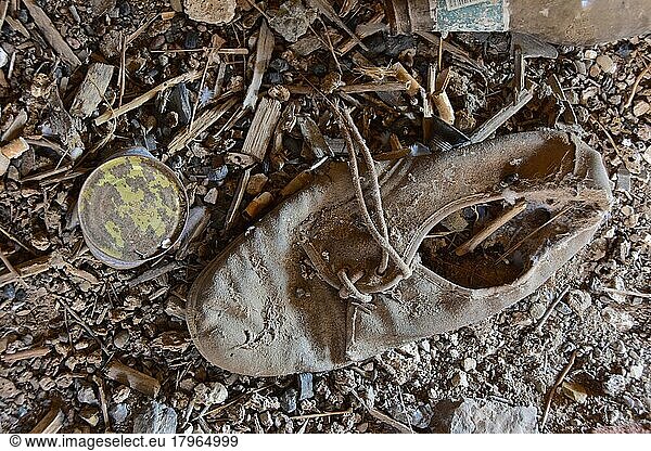 Maroder Halbschuh aus Leder am Boden  verrotteter Schuh  Schuhwrack  vergammelter Treter  ausgelatschter Schuh  abgetragener Schuh