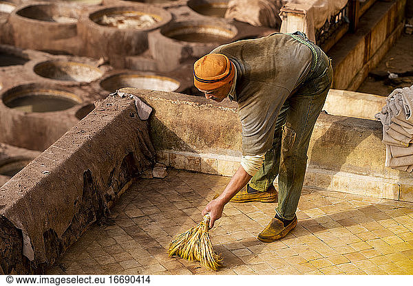 Marokkanischer Mann bei der Arbeit in einer Ledergerberei in Fez