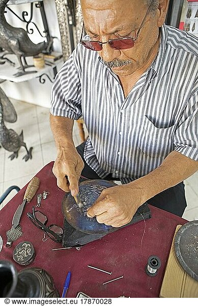 Marokkanischer Mann hämmert einen Silberfaden auf eine Metallplatte  Meknès  Marokko  Afrika