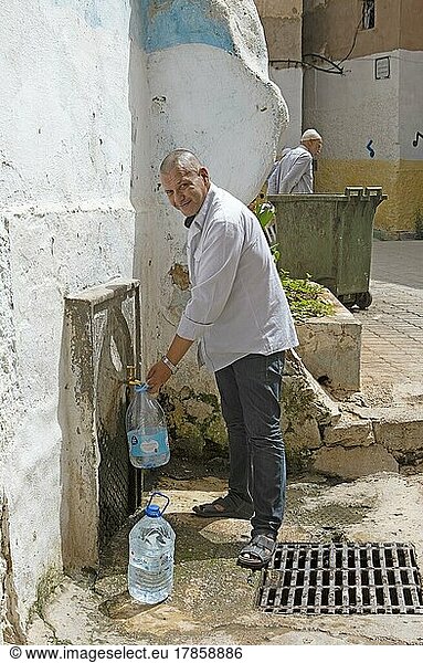 Marokkanischer Mann holt Trinkwasser an einer Zapfstelle  Altstadt  Fes  Marokko  Afrika