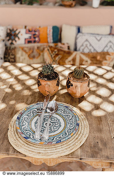 Marokko  Tisch mit zwei Topfkakteen und Besteck auf verziertem Teller liegend