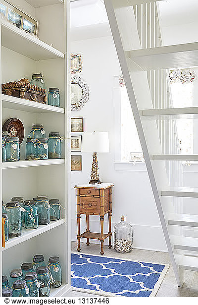 Mason jars arranged on shelves in living room at cottage