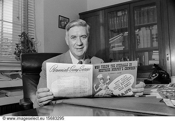 Massachusetts Congressman Thomas P. 'Tip' O'Neill  Half-Length Portrait sitting at Office Desk and holding Sheet Music  Washington  D.C.  USA  photograph by Thomas J. O'Halloran  August 1957