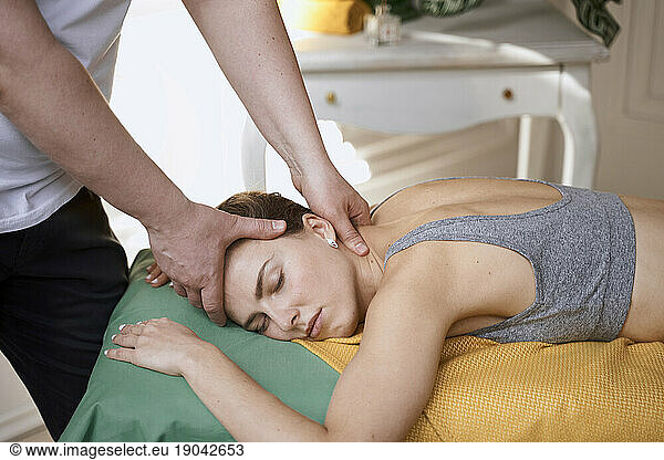 masseur works. man makes a beautiful woman massage