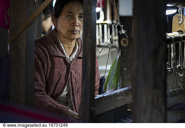 Mature Burmese woman weaving on loom  Lake Inle  Myanmar