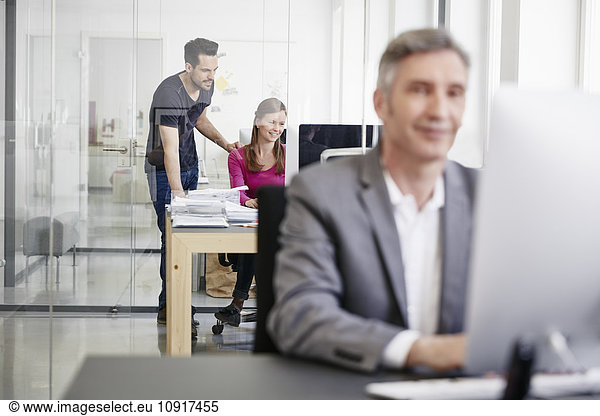 Mature businessman and coworkers working in office