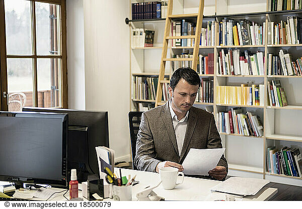 Mature businessman reading papers in an office  Bavaria  Germany