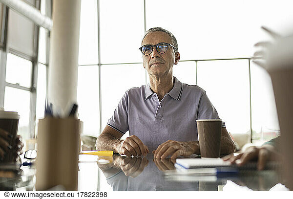 Mature businessman wearing eyeglasses sitting at desk