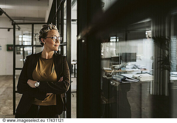 Mature businesswoman standing with arms crossed looking away