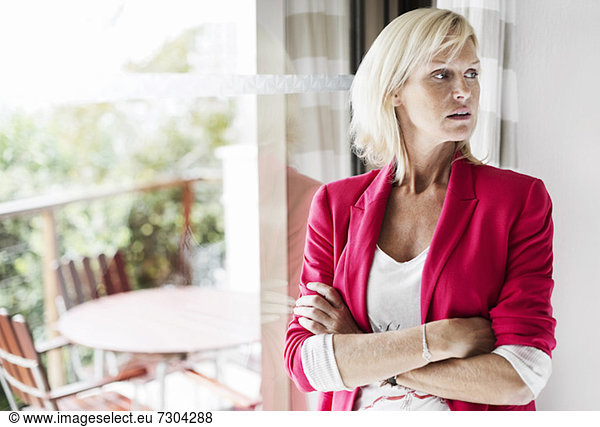 Mature businesswoman with arms crossed standing at office