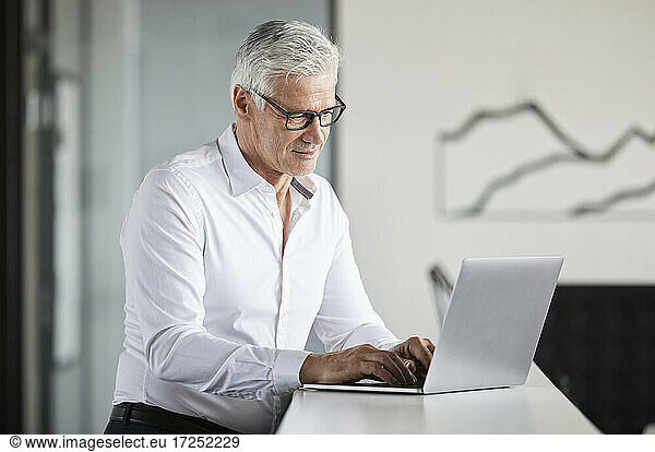 Mature businesswoman working on laptop in office