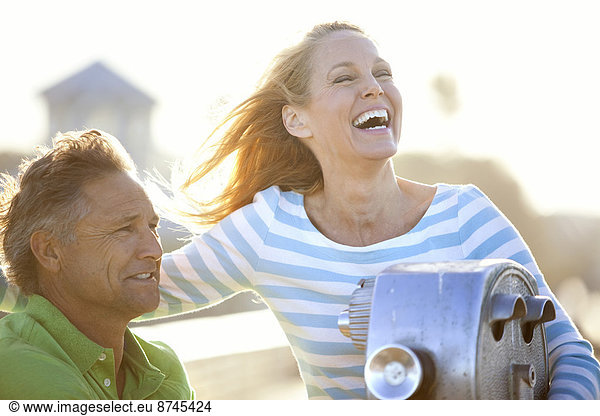 Mature Couple being Playful by Scenic Viewer on Pier  USA