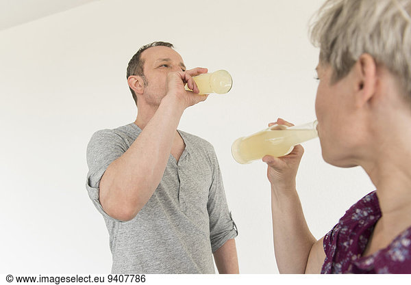 Mature couple drinking drink from bottle