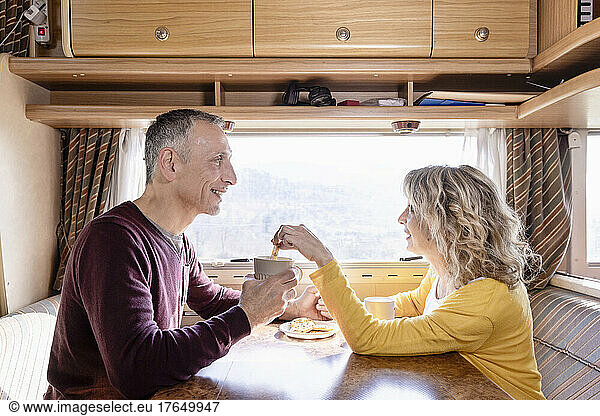 Mature couple having cookies in motor home on vacation