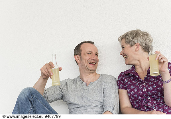 Mature couple holding drink bottle  smiling