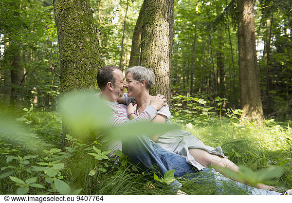 Mature couple kissing in forest