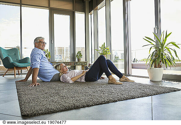 Mature couple relaxing at home on carpet