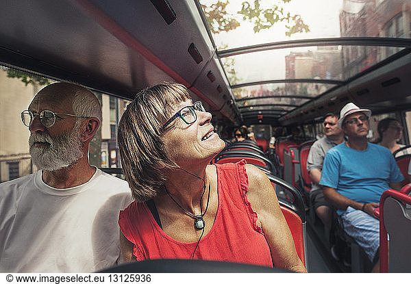 Mature couple travelling in bus on sunny day