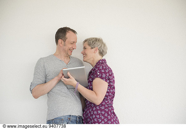 Mature couple using digital tablet  smiling
