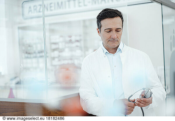 Mature doctor looking at stethoscope