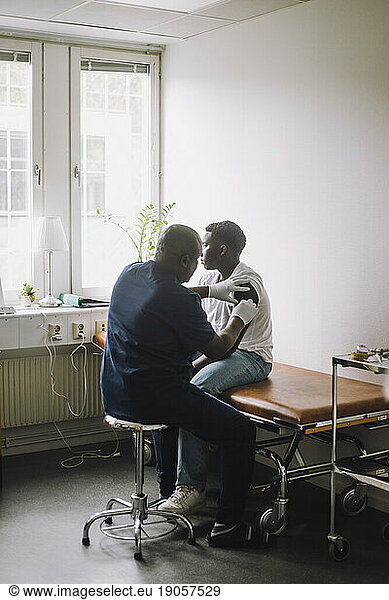 Mature male doctor giving vaccination to boy at hospital