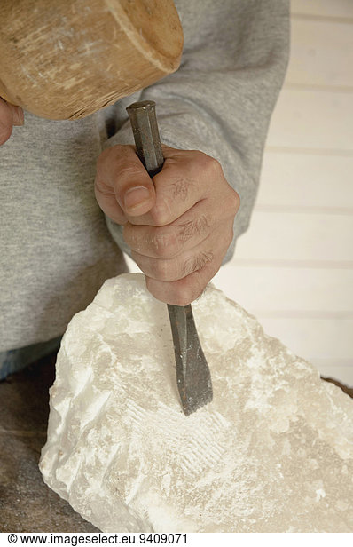 Mature man carving soapstone