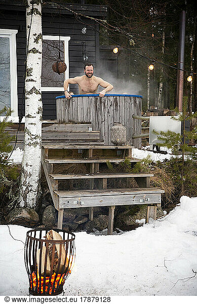 Mature man enjoying in hot tub outside house during winter