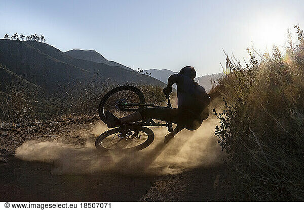 Mature man falling with mountain bike on trail in San Diego  CA
