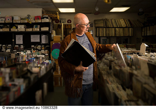 Mature man in record shop  filing records