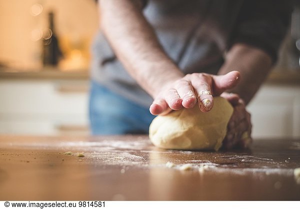 Mature man kneading dough