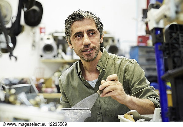 Mature man looking away while working in workshop