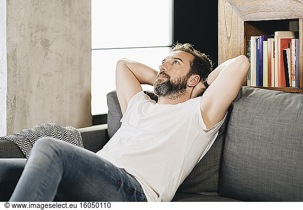 Mature man sitting on couch  contemplating