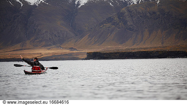 mature man steering his sea kayak through calm waters around Reykjavik