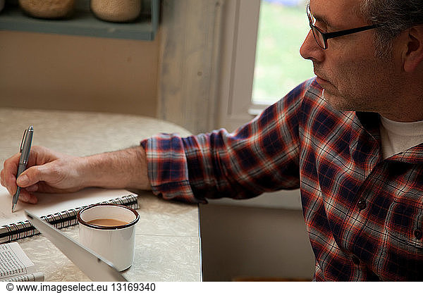Mature man taking notes at home