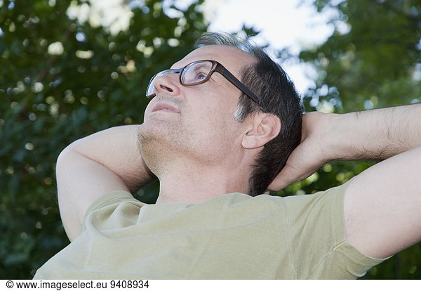 Mature man thinking and relaxing in garden
