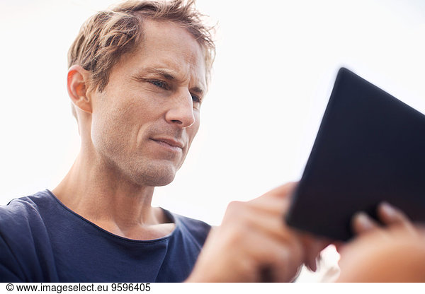 Mature man using tablet computer against clear sky