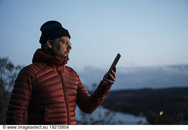 Mature man using tablet PC under blue sky