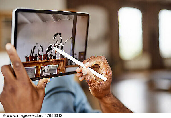 Mature man using tablet PC with digitized pen at home