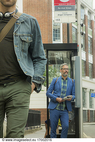 Mature man waiting while standing at bus stop