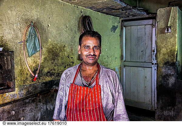 Mature man wearing apron in a kitchen in India; Amritsar  Punjab  India