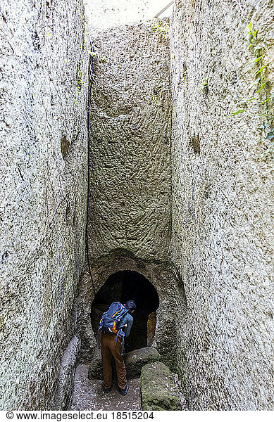 Mature man wearing backpack entering cave  Tuscany  Italy