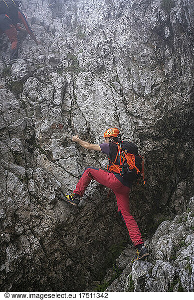 Mature man with backpack climbing on mountain  Bergamasque Alps  Italy