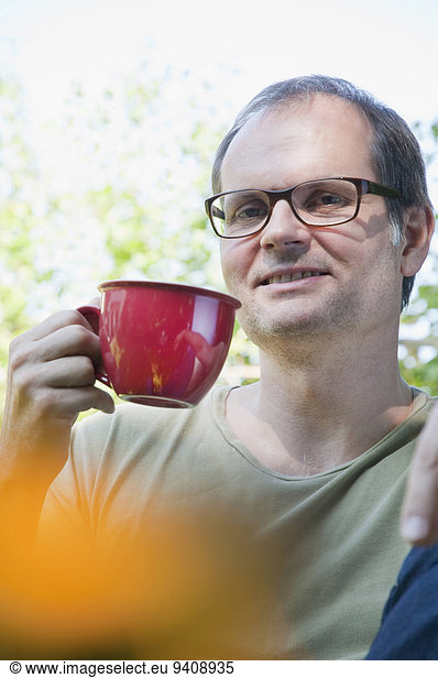 Mature man with cup of coffee  smiling  portrait